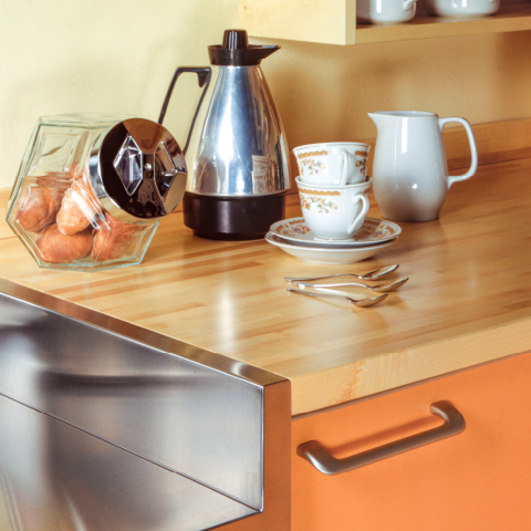 Arbeitsplatte mit Kaffeeservice und geöffneter Metallschublade.