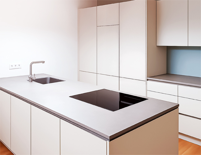 Maßgefertigte Küche mit Kochinsel, Induktionsfeld und Spüle.