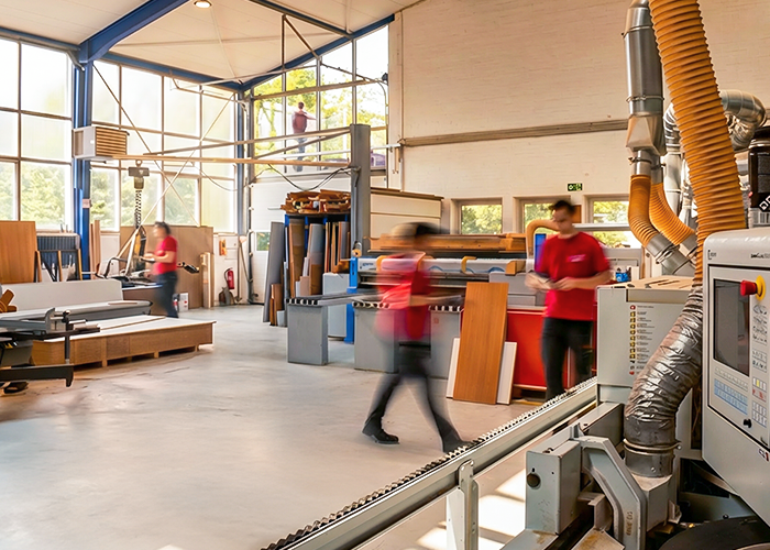 Produktionshalle von Clasen & Co mit Mitarbeitern und Maschinen in der Holzverarbeitung.